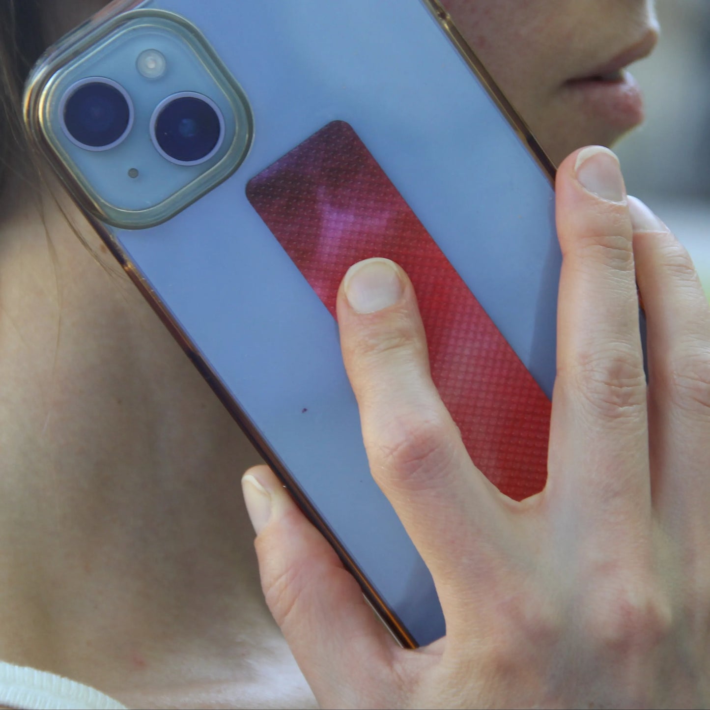 Roter Calm Strip an Handyhülle, Frau streicht beim Telefonieren mit gekrümmtem Finger darüber.