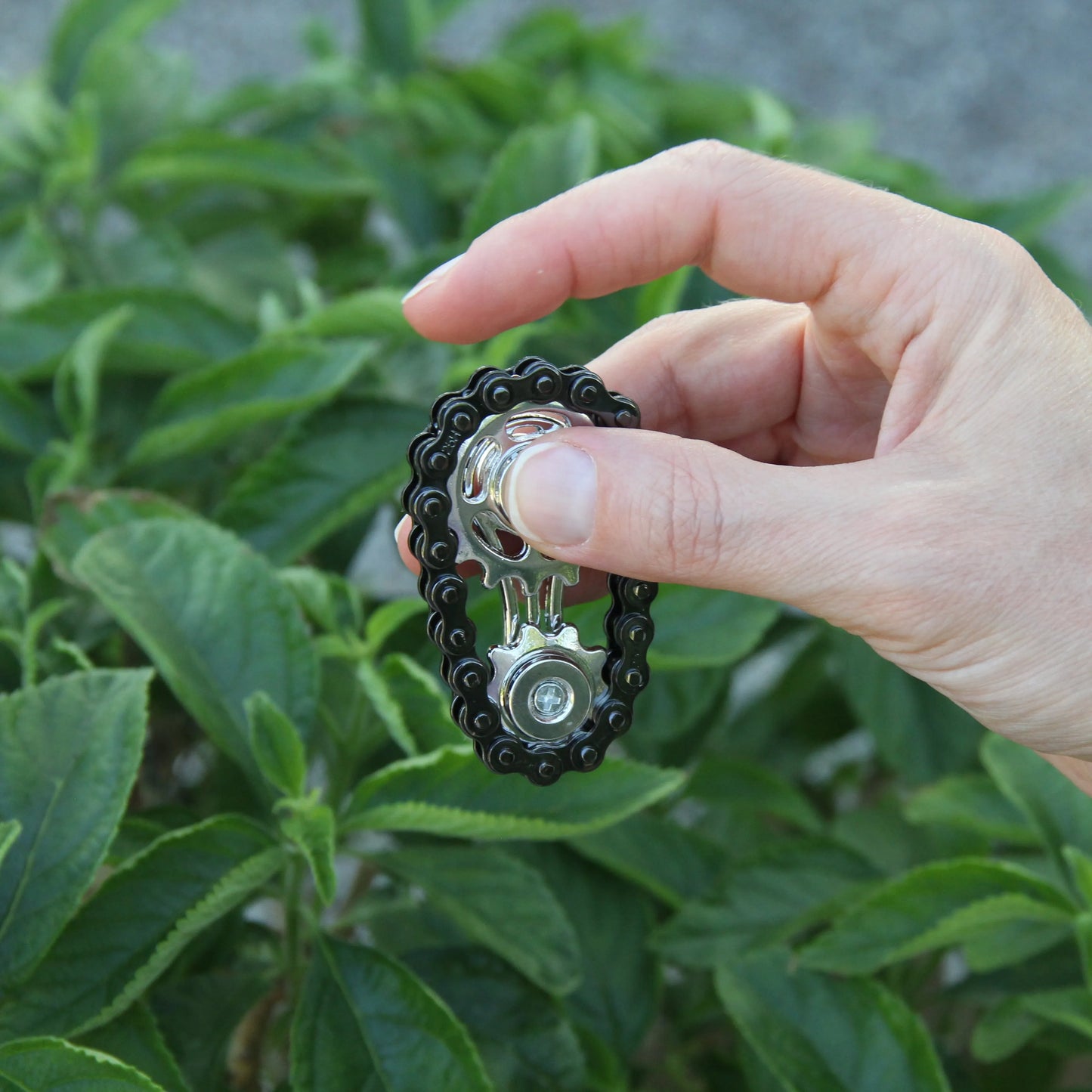 Frau hält die Chill Chain senkrecht in der Hand und spielt damit.
