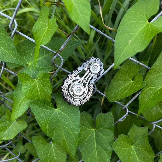 Chill Chain hängt an einem Zaun mit vielen grünen Blättern.