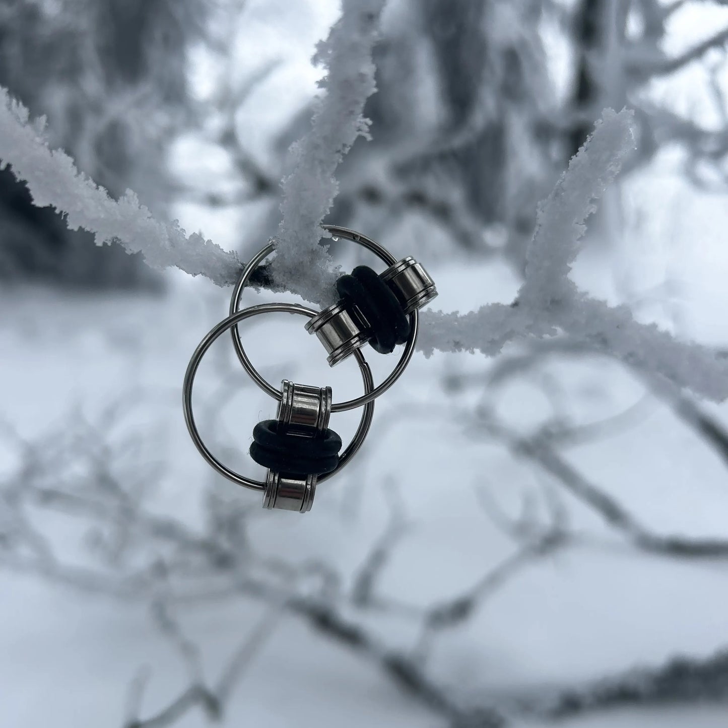 Finger Fidget Spielzeug hängt an einem Schnee bedeckten Ast.