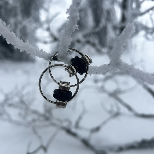 Finger Fidget Spielzeug hängt an einem Schnee bedeckten Ast.