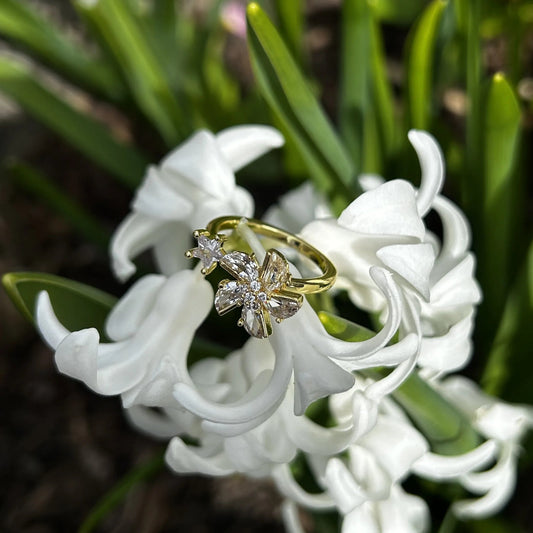 Ring mit eine Blume drauf, auf einer weissen Blume. 