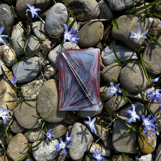 Zupfplättli auf Steinen mit blau weissen Blumen, welche zwischen den kleinen Steinen blühen.